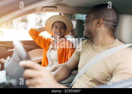Joyful black couple riding car together, enjoying road trip moment Stock Photo