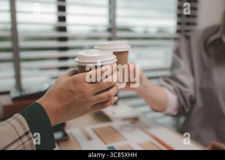 two female employees are celebrating after they successfully completed a project, business people celebrating success in an office, cheerful businessw Stock Photo