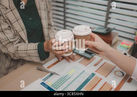 two female employees are celebrating after they successfully completed a project, business people celebrating success in an office, cheerful businessw Stock Photo