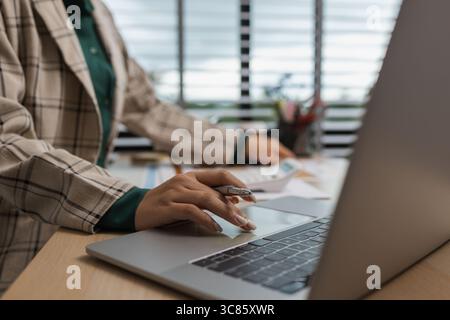 an employee sits working in an office full of documents that need to be completed on time, the marketing team leader is reviewing documents related to Stock Photo