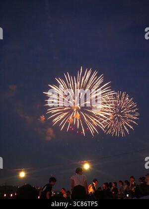 Golden fireworks illuminating the twilight sky above crowds at Tokyo’s Itabashi Fireworks Festival 2025 Stock Photo