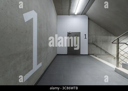 Concrete stairwell floor number one underground garage. Minimalist empty corridor in modern office building with number 1 marking. Ideal background te Stock Photo