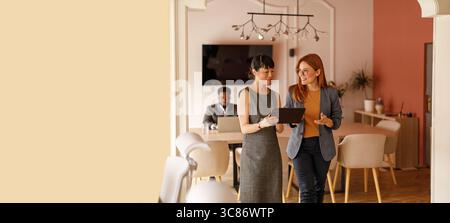 Team of businesswoman brainstorming ideas and analyzing data over digital tablet during corporate meeting Stock Photo