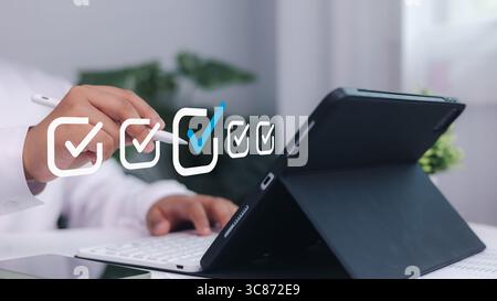 Checkmark concept, Businessman using digital pen to check task list on tablet screen. Concept of productivity, digital planning, project management, a Stock Photo