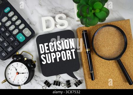 DS Decision Support text with Calculator, alarm clock and magnifying glass on marble background Stock Photo