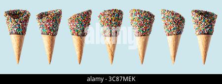 Set of empty wafer ice cream cones with colorful candy sprinkles on blue background. Banner design. Stock Photo