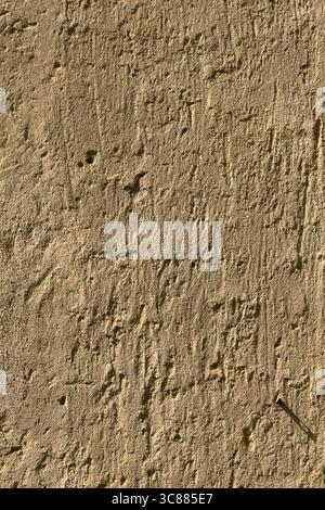 The scratched up surface of an old European stucco wall creates a textured background plate. Stock Photo