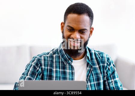 Black Business Guy Working At Laptop Taking Notes In Office Stock Photo