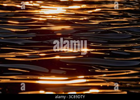 Gilded Ripples Dance Upon Molten Waters Stock Photo