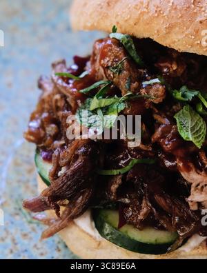 Close up on a pulled pork burger sandwich seasoned with fresh mint Stock Photo