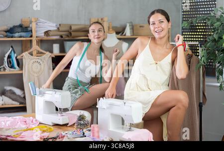 Female dressmakers doing a warm-up in the workshop in summer Stock Photo