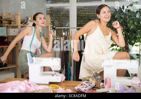 Female dressmakers doing a warm-up in the workshop in summer Stock Photo