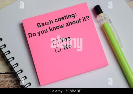 Batch costing do you know about it write on sticky notes isolated on Wooden Table. A person is answering question concept Stock Photo