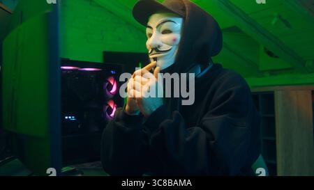 Lviv, Ukraine - June 03, 2024: Hacker man anonymous dangerous computer pc criminal stealing information online datum hooded mysterious person coding Stock Photo