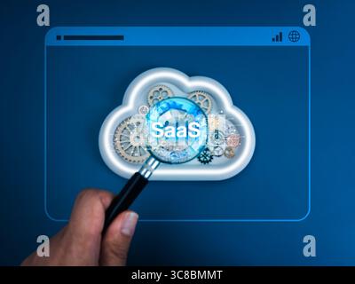 SaaS, software as a service, offers software access online, technology concept. Text "SaaS" on cloud storage service with gears management in magnifyi Stock Photo