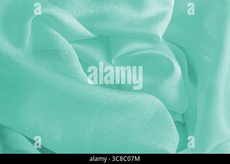 Beautiful silk fabric texture background in delicate turquoise color. soft waves of fabric. copy space. Abstract holiday background for design. layout Stock Photo