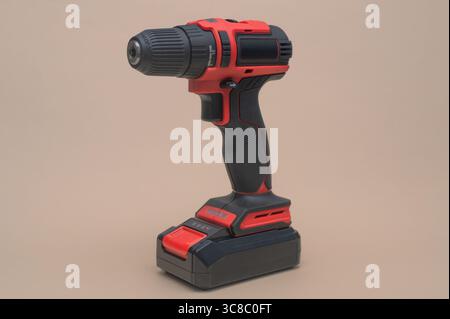Cordless electric drill standing on neutral background, showcasing modern ergonomic design and rechargeable battery. Compact and powerful cordless dri Stock Photo