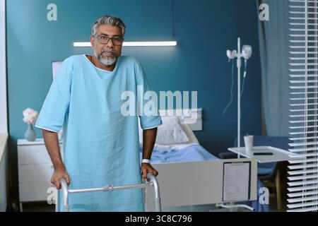 Middle Aged Biracial Man Using Walker Recovering in Hospital Room Stock Photo