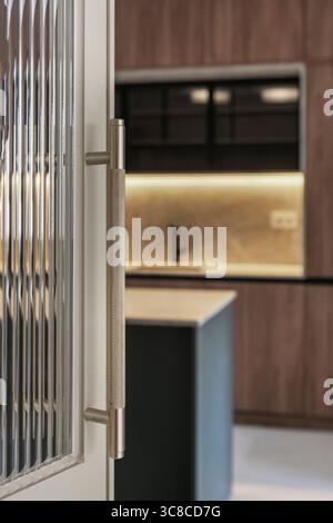 Minimalist perfection: straight-lined chrome handle gleaming against pristine white lacquered door surface in contemporary interior space Stock Photo