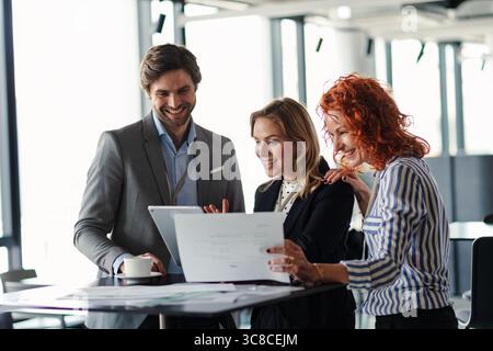 Business colleagues sharing ideas, discussing new project. Stock Photo