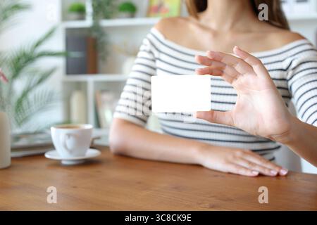 Close up of a woman hand showing blank credit card on a table at home Stock Photo