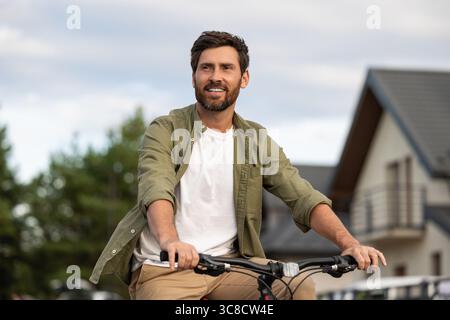 Bearded caucasian young man on a bike looking confident Stock Photo