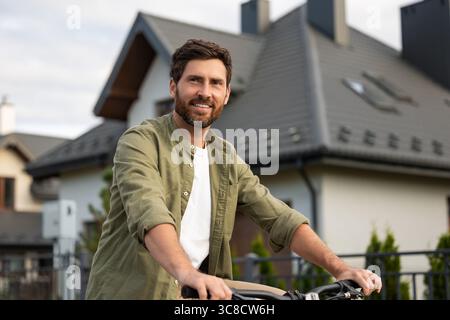 Bearded caucasian young man on a bike looking confident Stock Photo