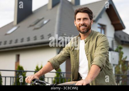 Bearded caucasian young man on a bike looking confident Stock Photo