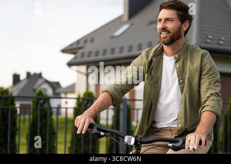 Bearded caucasian young man on a bike looking confident Stock Photo