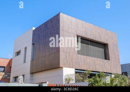 Striking Modern House With Wood Like Cladding And Minimalist Design Under Blue Sky. Contemporary architecture, luxury home, exterior view, building Stock Photo