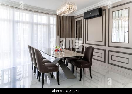 Oval light modern table and chairs with dark upholstery. A room in a minimalist style Stock Photo