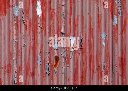 Close-up of red peeling paint on a corrugated surface., Stock Photo