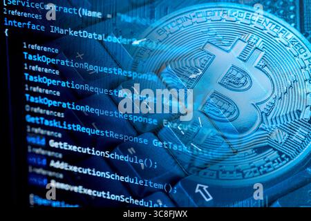 Information technology concept. Coding programmer language script text on screen monitor display with a PC keyboard and bitcoin cryptocurrency. Select Stock Photo