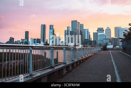 Sunset over Canary Wharf skyline, London, with dramatic clouds and golden light. Stock Photo