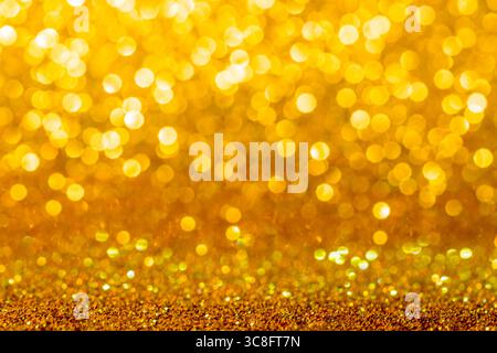 Gold yellow glitter foil background. Shiny metal gold foil texture abstract defocused background. Sparkle glitter texture with bokeh lights. Stock Photo