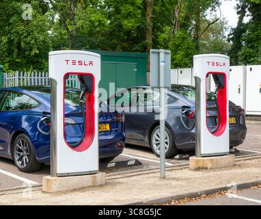 Tesla Supercharger station charging bays for  electric vehicles at service station, M25 South Mimms services, Hertfordshire, England, UK Stock Photo