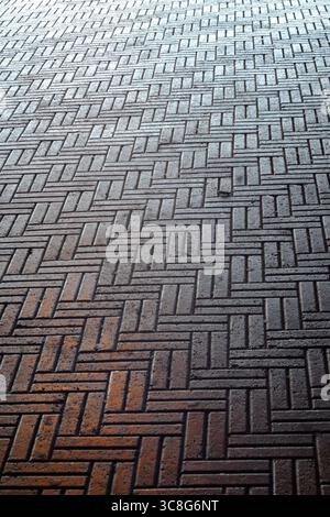 Rectangular bricks interlocking in herringbone arrangement, generating textured pavement surface pattern Stock Photo