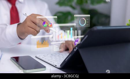 Analytics dashboards and floating holographic charts displayed as a person uses a stylus on a tablet. Concept of modern business analysis, financial p Stock Photo