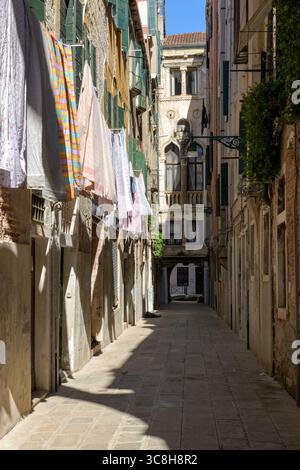 Narrow alley in Venice (Venezia), Italy, with hanging laundry and Renaissance facades, capturing the authentic charm of everyday life in the historic Stock Photo
