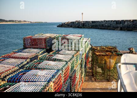 Fishing Equipment with Lobster Pots on a Harbor Pier. Concept The tools of the fishing trade. Stock Photo
