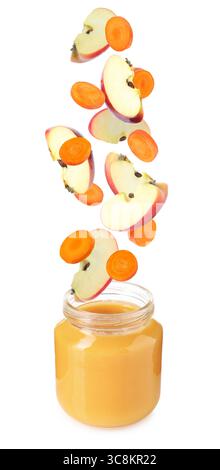 Baby food. Apple and carrot slices falling into jar of puree on white background Stock Photo