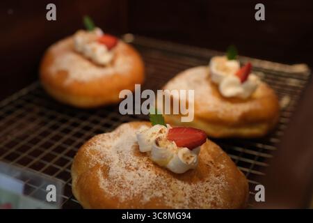 A close-up view of a plain, golden donut, free of glaze or toppings. The classic, fluffy texture and timeless charm of this unadorned treat make it a comforting delight all. High quality 4k footage Stock Photo
