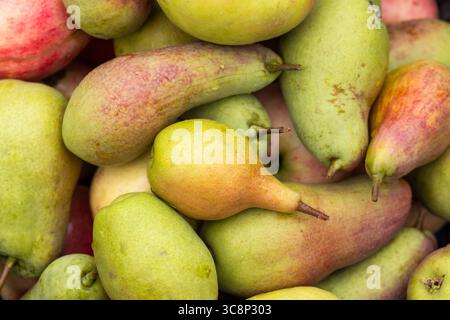 An array of fresh, vibrant pears in varying shades and textures, arranged closely together, showcasing their natural appeal and variations Stock Photo