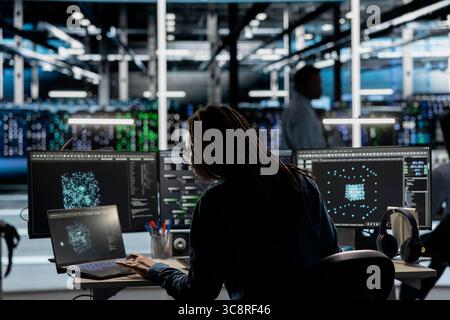Data center system administrator uses AI visualization tool to optimize resource allocation. Server farm staff member uses artificial intelligence analysis software on computer to do maintenance Stock Photo