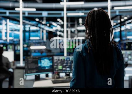 System administrator entering data center office, preparing to use artificial intelligence computerized model. Server room employee arriving at work, starting job shift, using AI Stock Photo