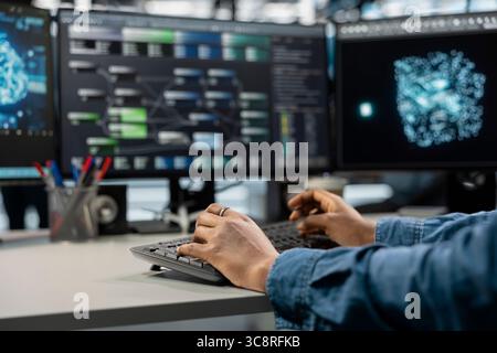 Close up of data center professional using machine learning algorithms to analyze large datasets. Server farm engineer typing on keyboard, using artificial intelligence to recognize data patterns Stock Photo