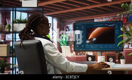 Person at home getting tasks done with AI program turning text prompt into videos. Woman using computer to make use of text to video artificial intelligence generative models, camera A Stock Photo