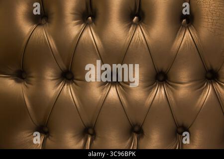The texture of the upholstery of a leather sofa with silver rivets. Stock Photo