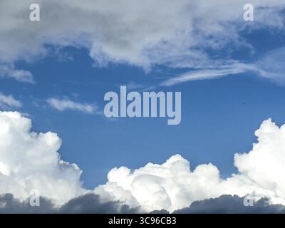 At the bottom of the picture grey white cumulus clouds, at the top altostratus in front of blue sky, International Stock Photo
