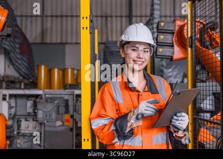 Smart engineer Asian women profession robot technician worker happy smiling in modern factory robotic industry Stock Photo
